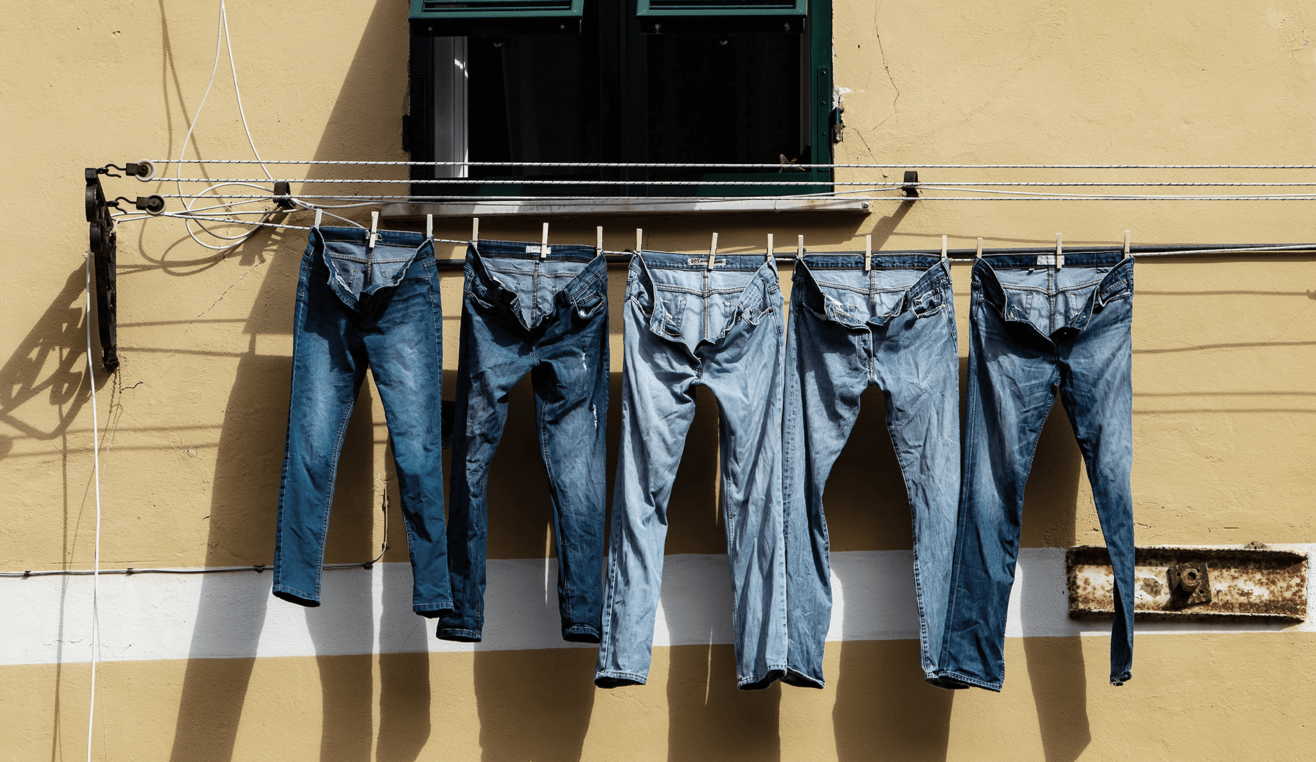 Sustainable Denim jeans hanging on a clothing wire to dry