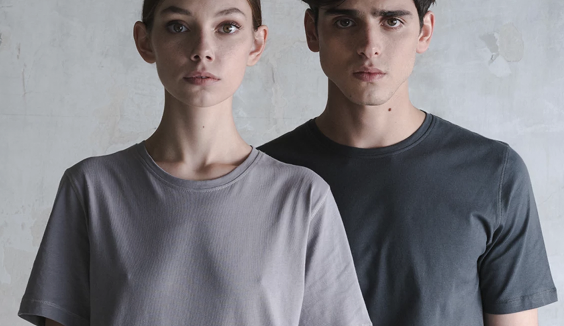 image of a woman and man wearing grey t-shirts against a grey background